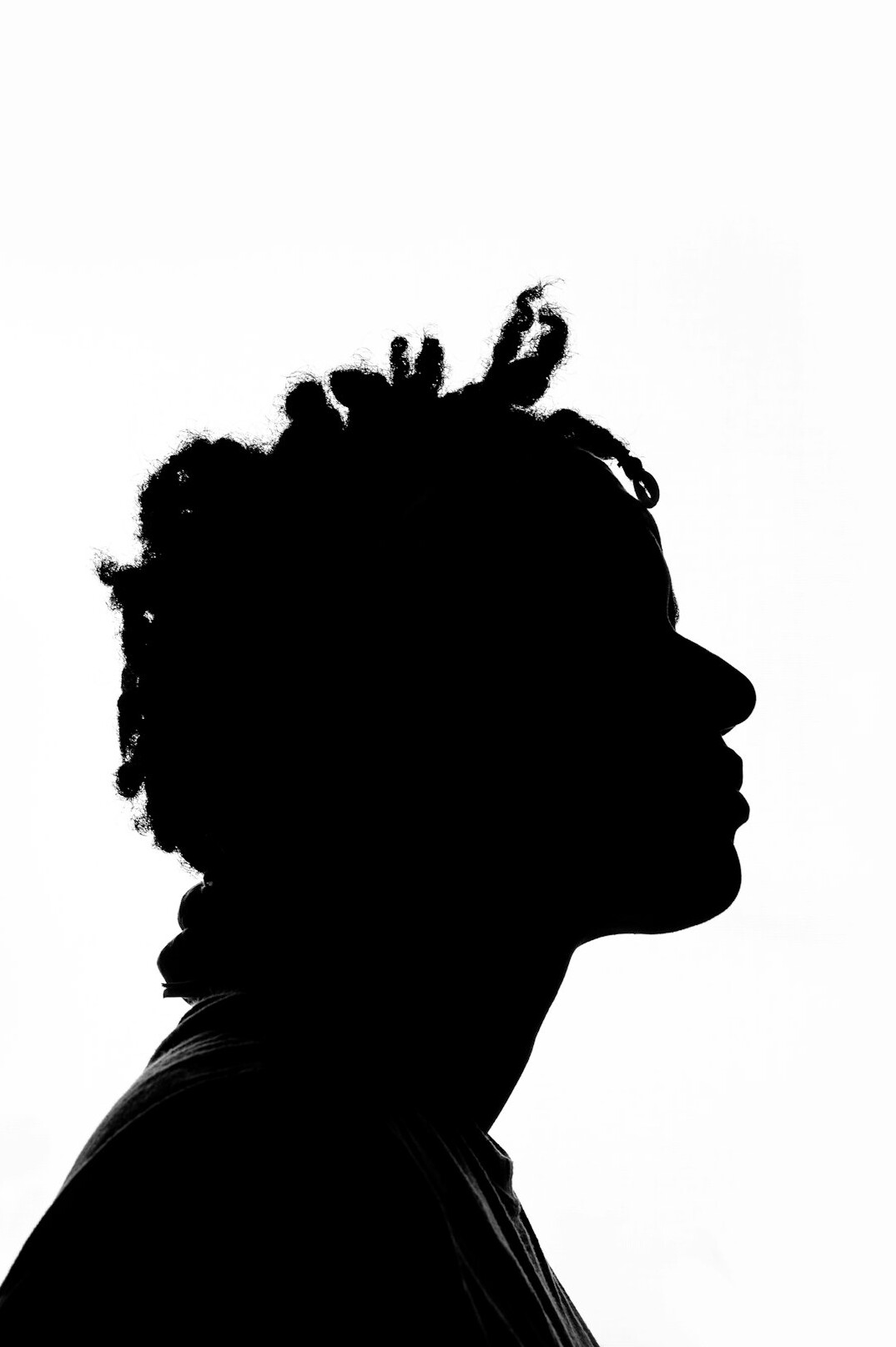 Silhouette einer Person, die nachdenklich aus einem Fenster blickt
